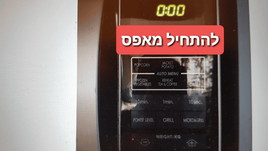 לוח הבקרה של המיקרוגל מציג את השעה 0:00 עם כיתוב גרפי אדום בעברית שמשמעותו “איפוס לאפס”.